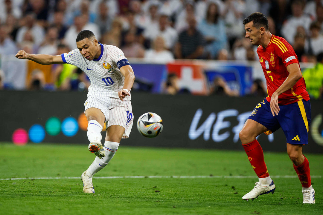 El delantero de la selección francesa Kylian Mbappé (i) chuta ante el español Daniel Vivian, durante el partido de semifinales de la Eurocopa de fútbol que España y Francia disputan este martes en Múnich. EFE/Alberto Estévez