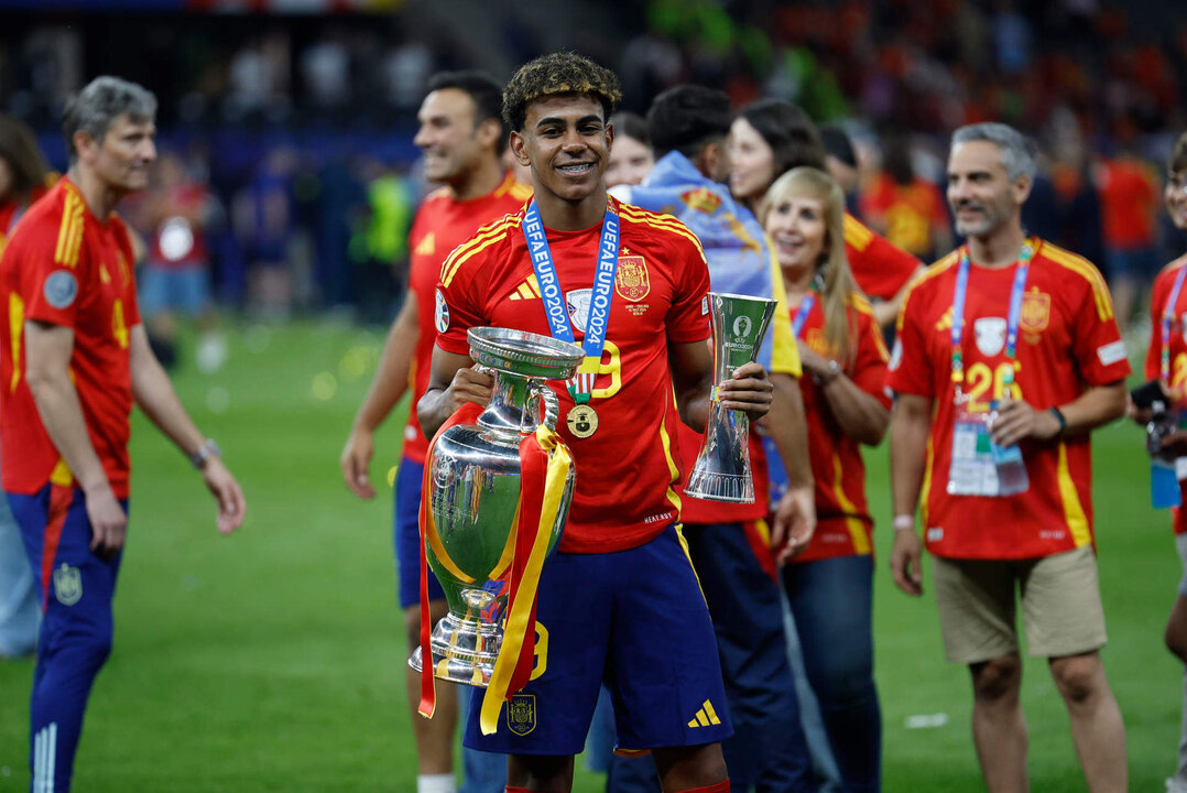 El jugador de la selección española Lamine Yamal, mejor jugador más joven del campeonato, con el trofeo durante la celebración de la victoria de la Eurocopa, tras vencer a Inglaterra en el partido de la final disputado en el Estadio Olímpico de Berlín. EFE/Alberto Estévez