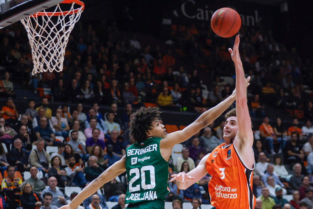 El ala pivot estadounidense de Valencia Basket, Nathan Reutvers (d), lanza a canasta ante el jugador francés de Cedevita Olimpia Ljubljana, Joan Beringer, durante el encuentro de la fase regular de la Eurocopa que disputaron en el pabellón Fuente de San Luis de Valencia. EFE/Miguel Ángel Polo.