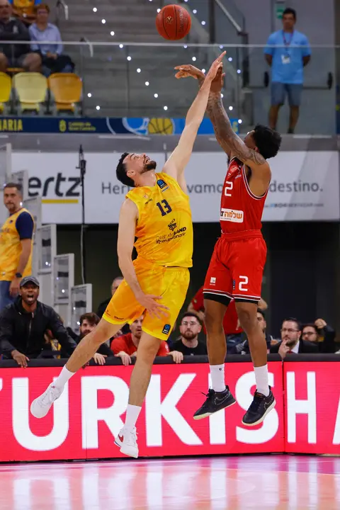 El alero francés de Gran Canaria, Pierre Pelos (i), defiende el lanzamiento del jugador del Hapoel Tel Aviv durante el segundo partido de la final de la Eurocopa que Dreamland Gran Canaria y Hapoel Tel Aviv disputan este viernes en Las Palmas. EFE/Elvira Urquijo