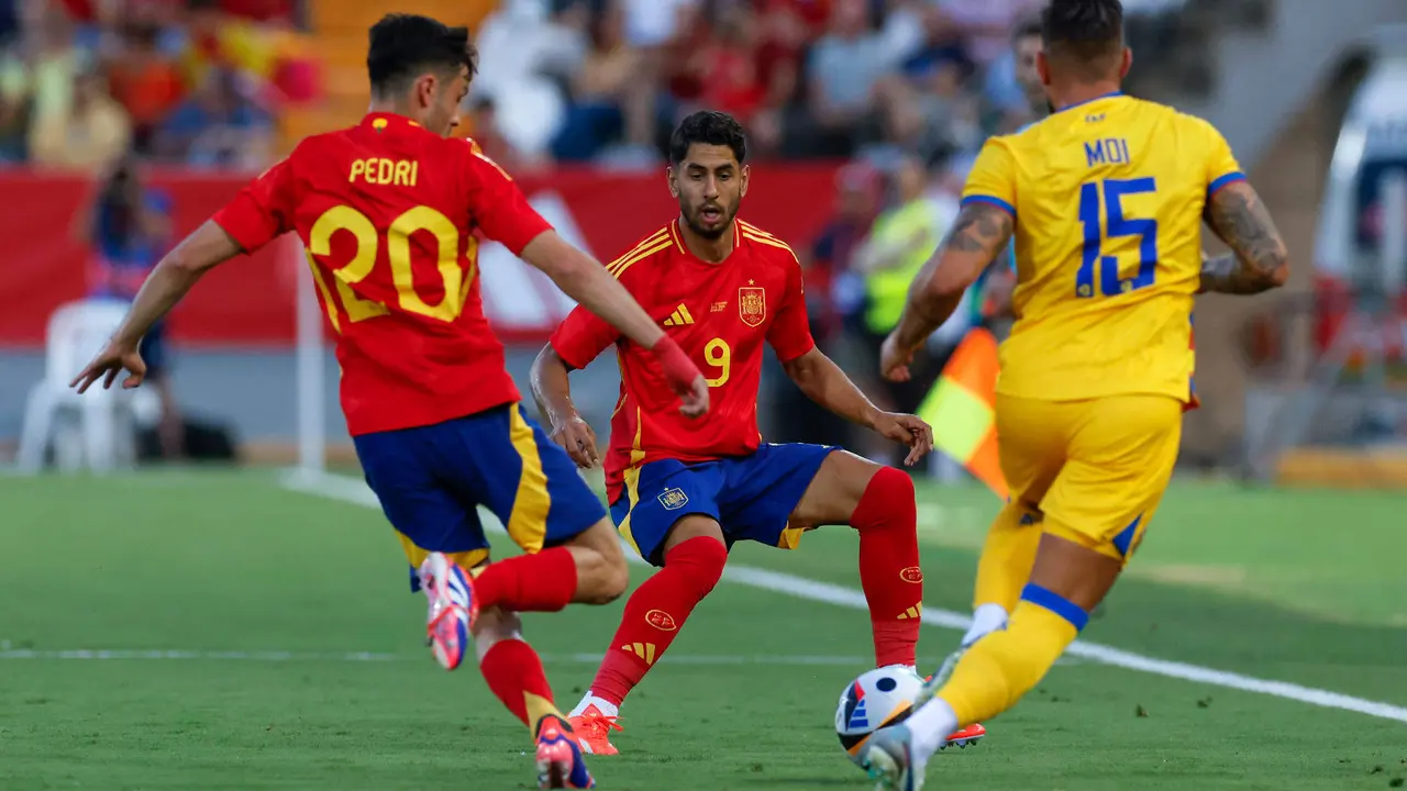 El defensa de la selección andorrana de fútbol Moisés San Nicolás (d) pelea un balón con Pedri (i) y Ayoze Pérez, ambos de España, durante el partido amistoso que España y Andorra disputan este miércoles en el estadio Nuevo Vivero, en Badajoz. EFE/Julio Muñoz