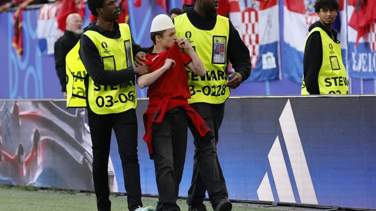 La seguridad saca del campo a un hincha de Albania en el estadio en Hamburgo, Alemania. EFE/EPA/ROBERT GHEMENT