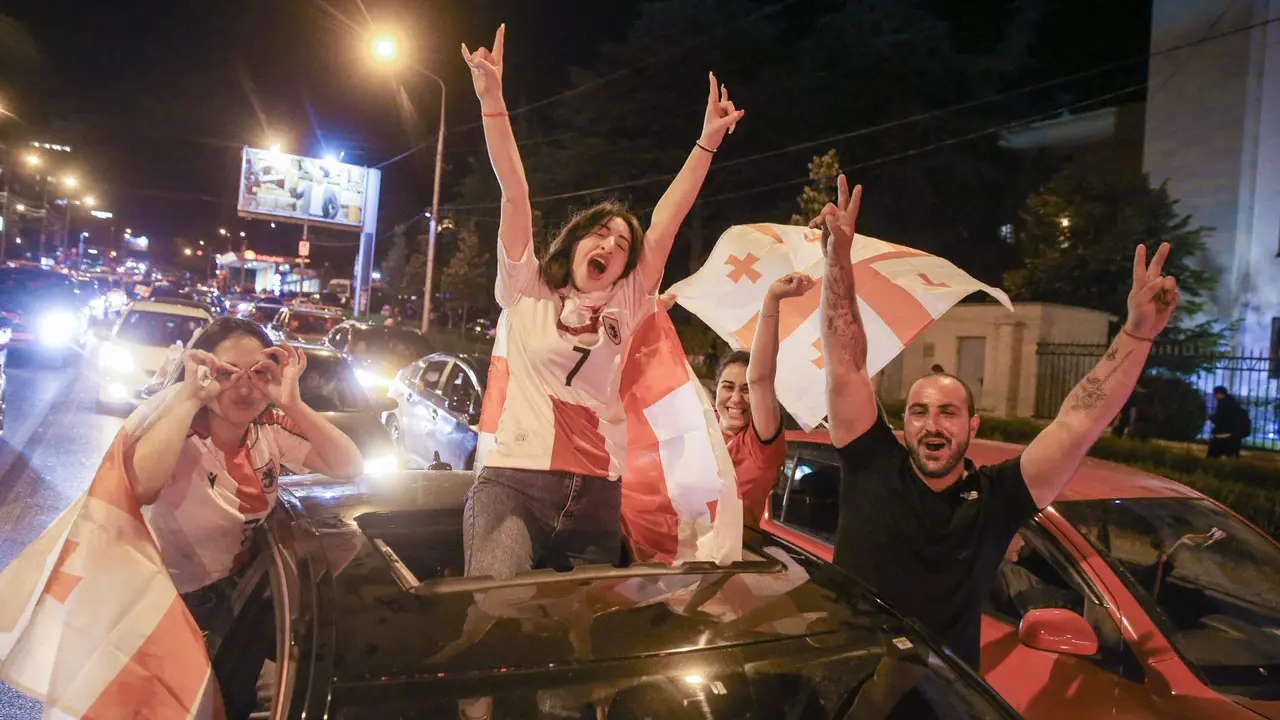 Decenas de miles de aficionados se volcaron anche a la calles de Tiflis y otras ciudades de Georgia para celebrar hasta altas de la madrugada la victoria (2-0) de la selección nacional sobre Portugal que le dio el pase a octavos de final del Eurocopa, donde le espera España.En medio del estruendo de los fuegos artificiales y de los cláxones de los automóviles engalanados con la rojiblanca bandera del país se oían los gritos de júbilo de los aficionados por el histórico logro del fútbol georgiano en su primera participación en un torneo continental.  EFE/ Misha Vignanski.